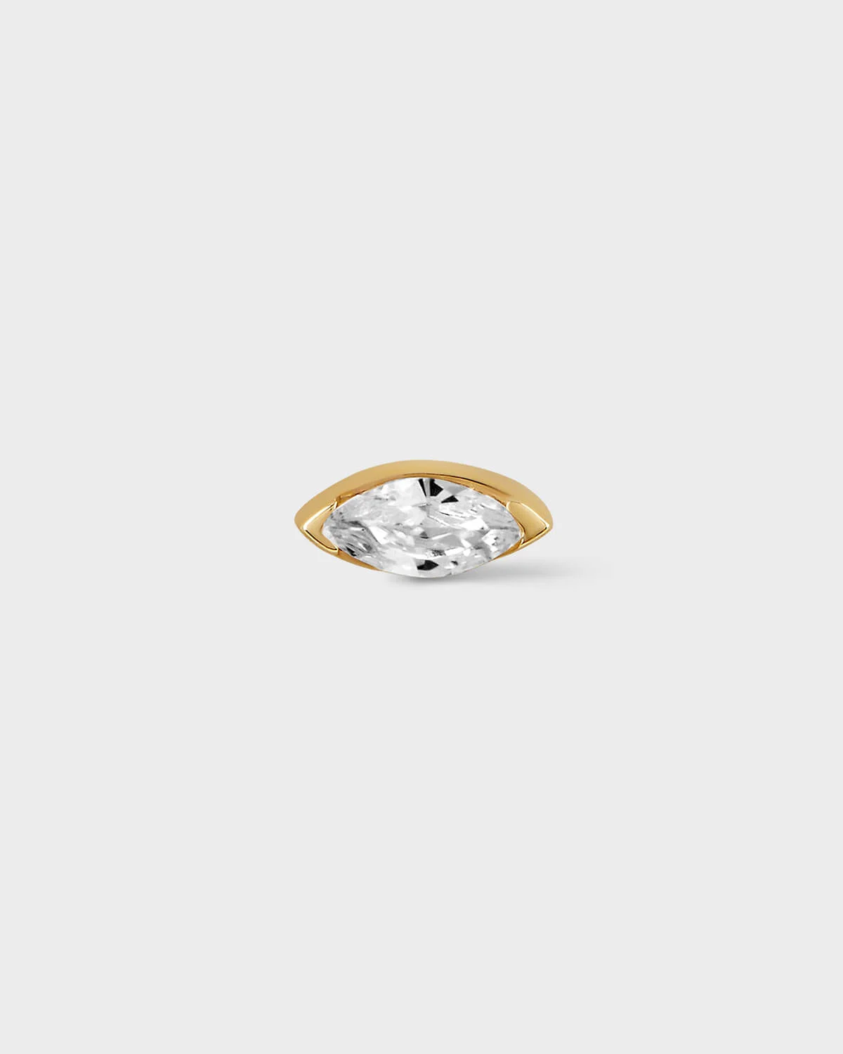 Gold earring with marquise gem on light grey background