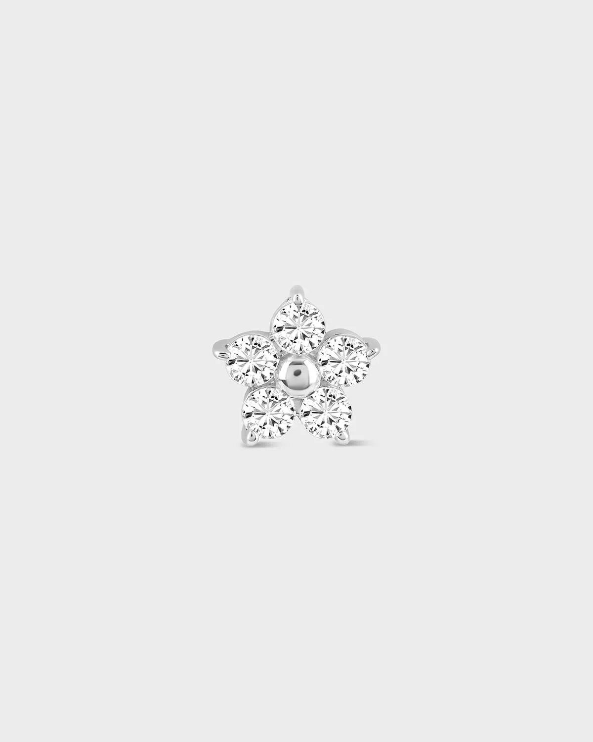 Flower shaped diamond earring on a light gray background