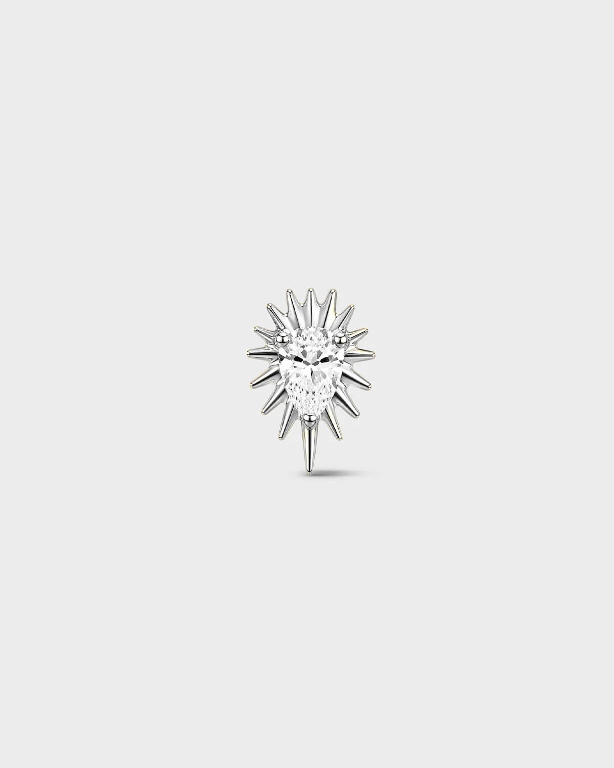 Polished silver titanium threadless end earring with a pear-cut clear stone set within a sculpted starburst design. On a light grey background.