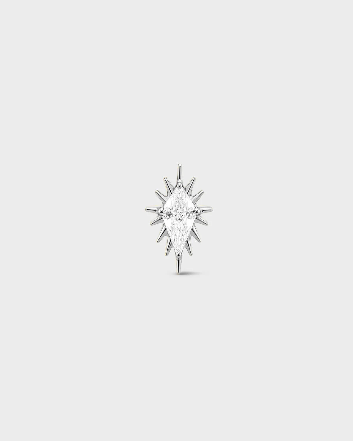 Polished silver titanium threadless end earring with a marquise-cut clear stone set within a sculpted starburst design. On a light grey background.