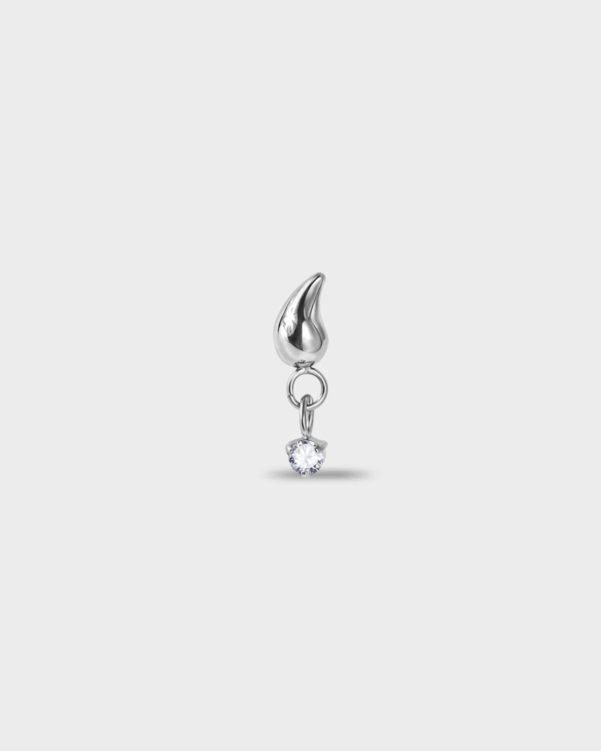 Polished silver titanium earring with a tear drop shape at the top and a suspended clear solitaire dangle on a light gray background