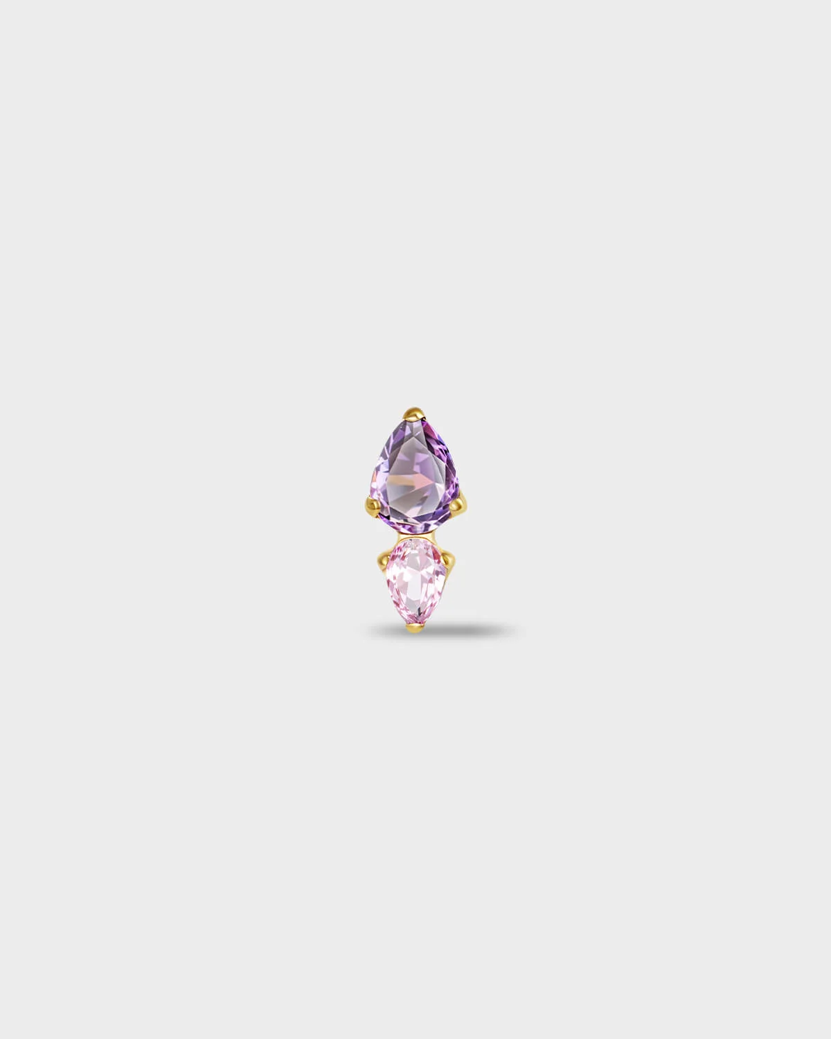 Gold titanium earring with a pear-cut purple stone set above a smaller pear-cut pale pink stone on a light gray background.