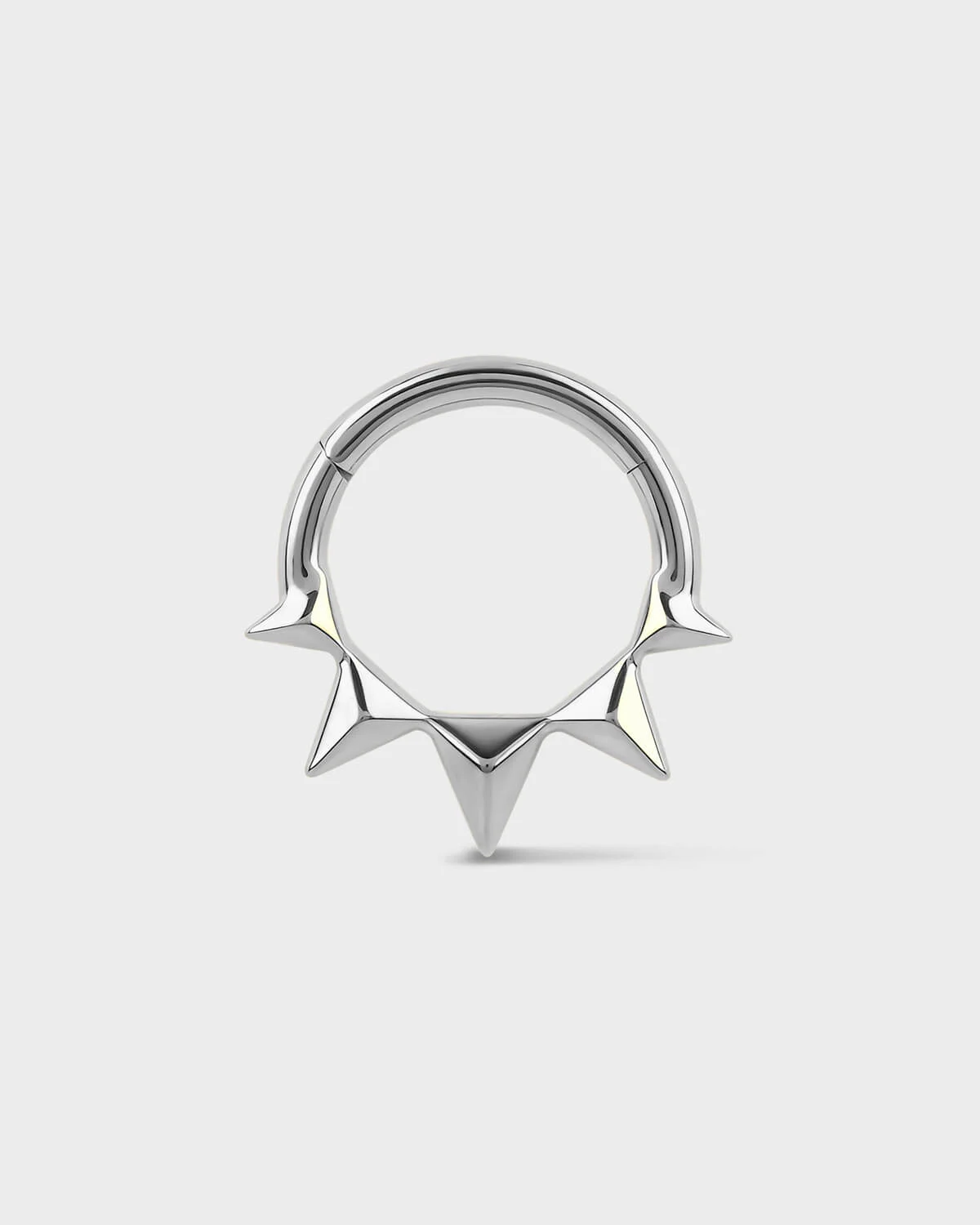 Silver septum ring with spike design on a white background