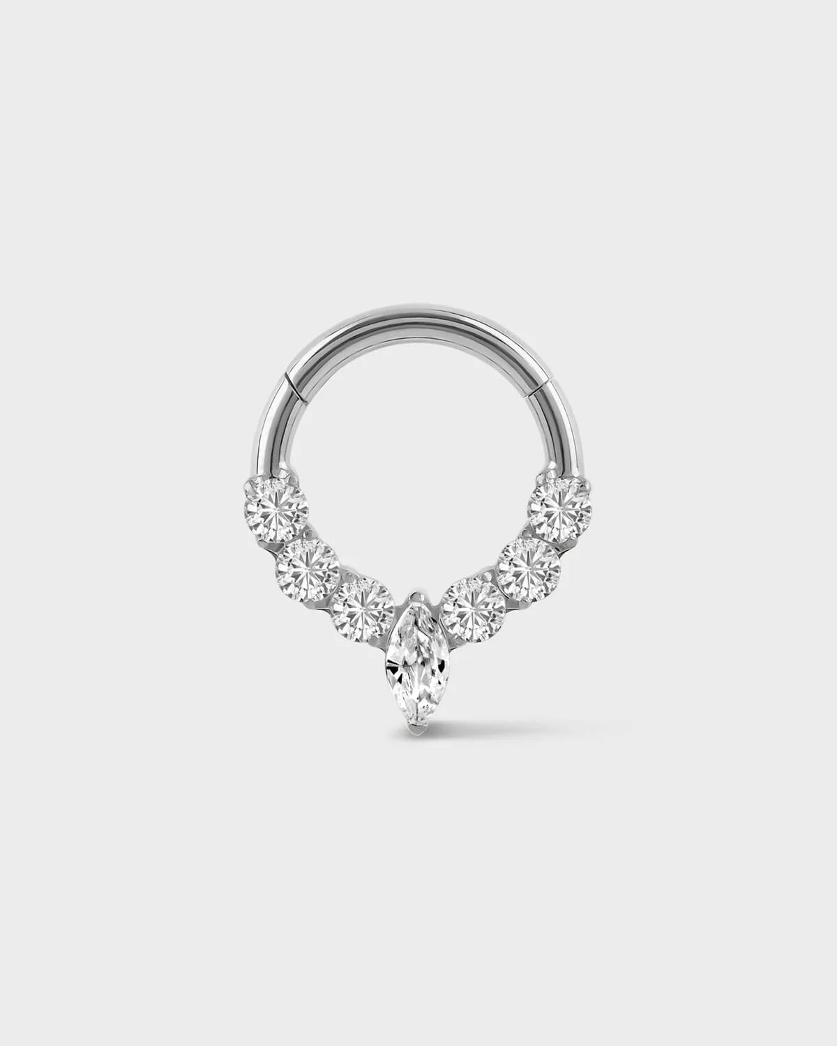 silver daith ring with central marquise gemstone and three gem either side on a light gray background