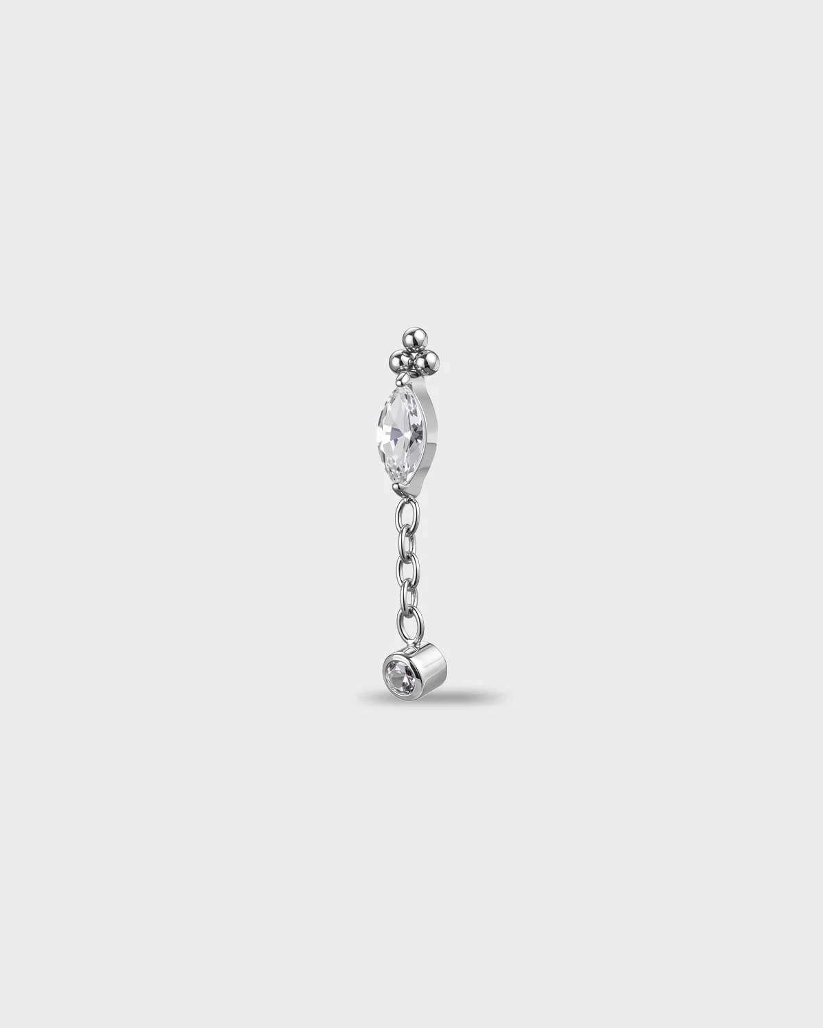 Polished titanium earring with a marquise-cut clear stone, a short chain dangle, and a small round-cut clear stone in a bezel setting, on a light gray background.
