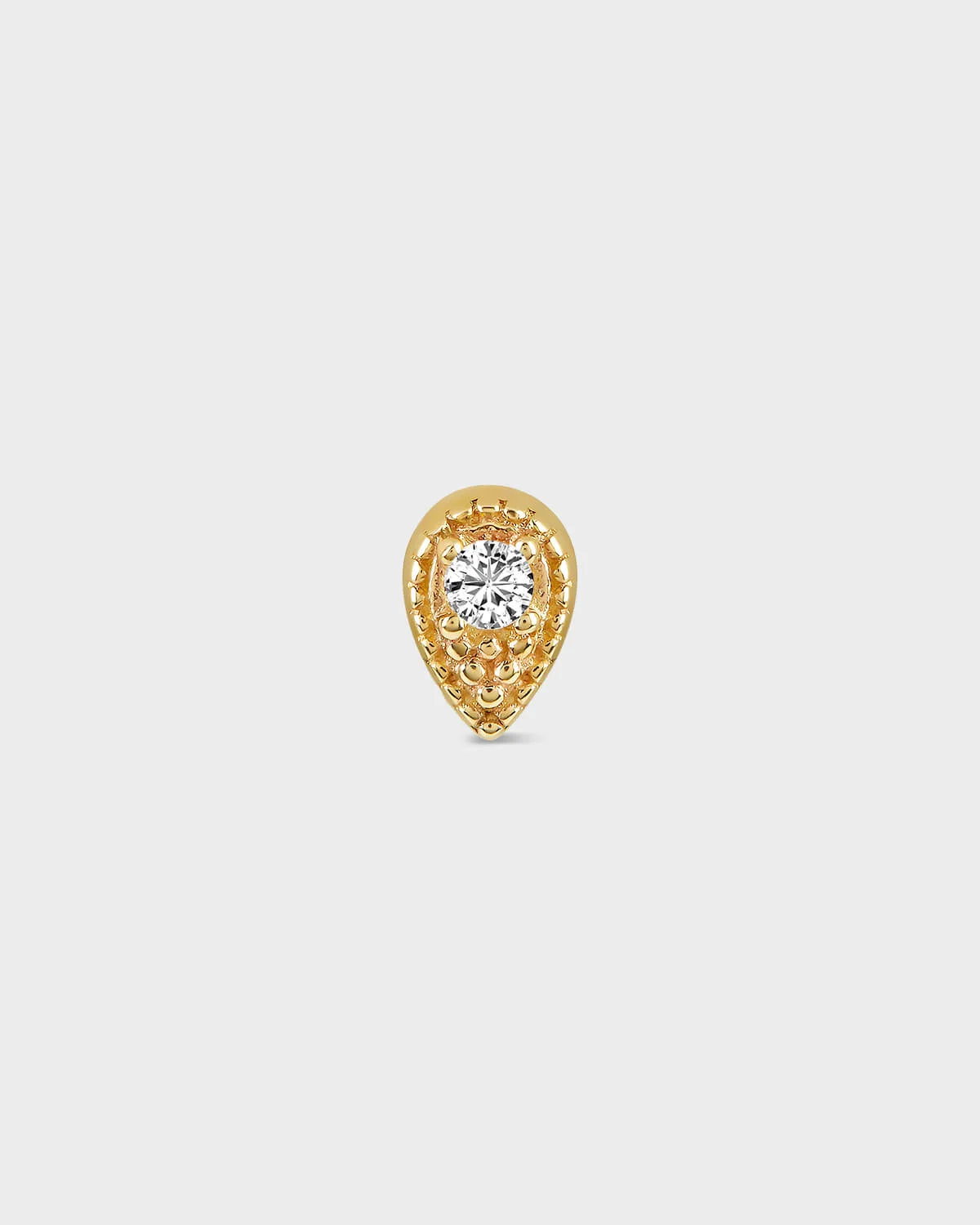 Gold teardrop-shaped earring with a diamond on a light gray background