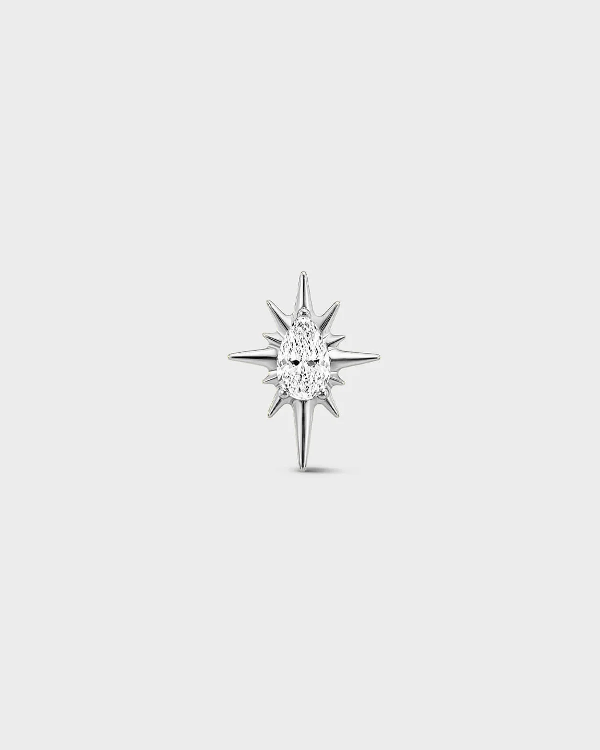 Polished silver titanium threadless end with a marquise-cut clear stone set within a sculpted starburst design. On a light grey background.