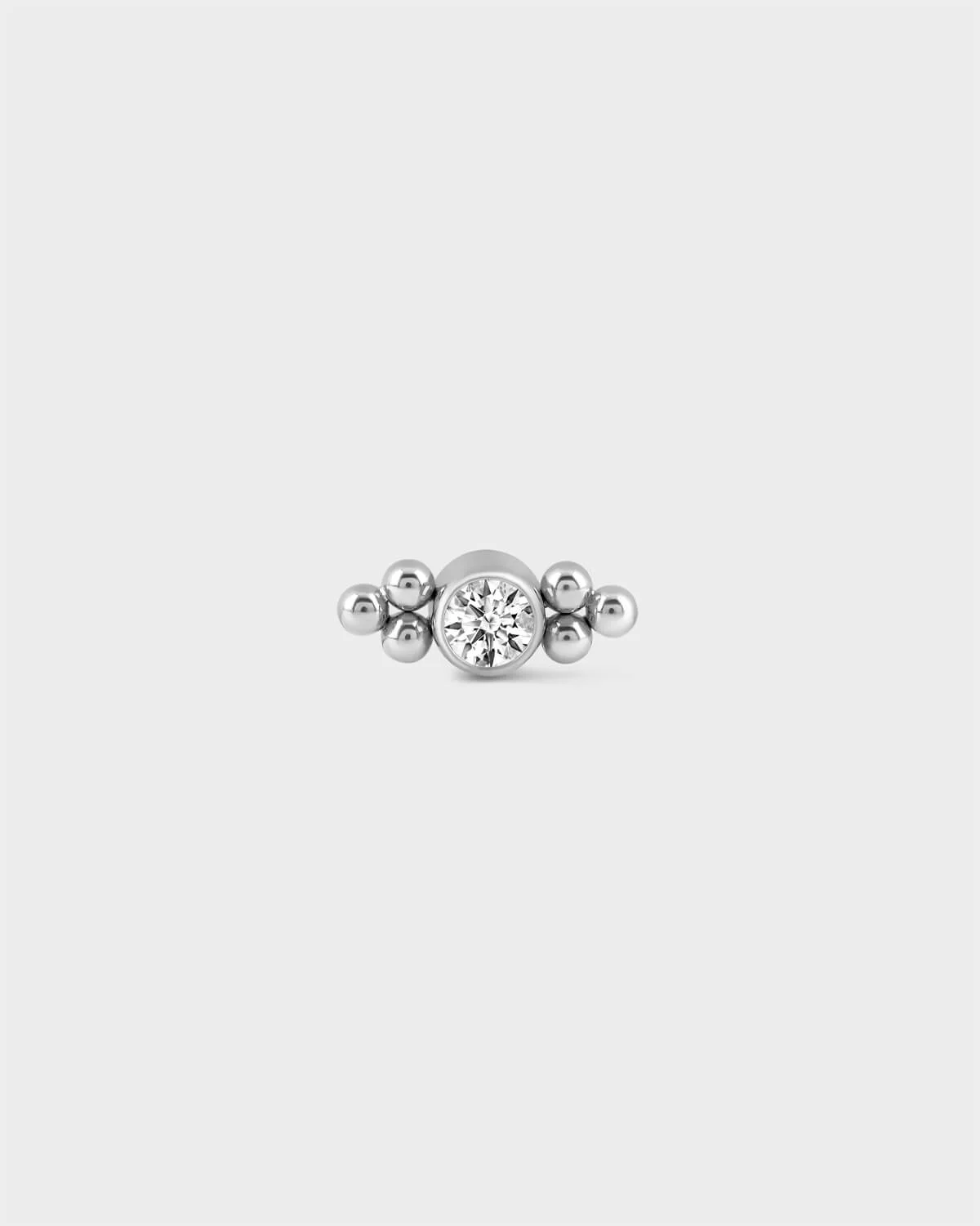 Polished titanium bezel set solitaire earring with 3 bead detailing either side on a light grey background.