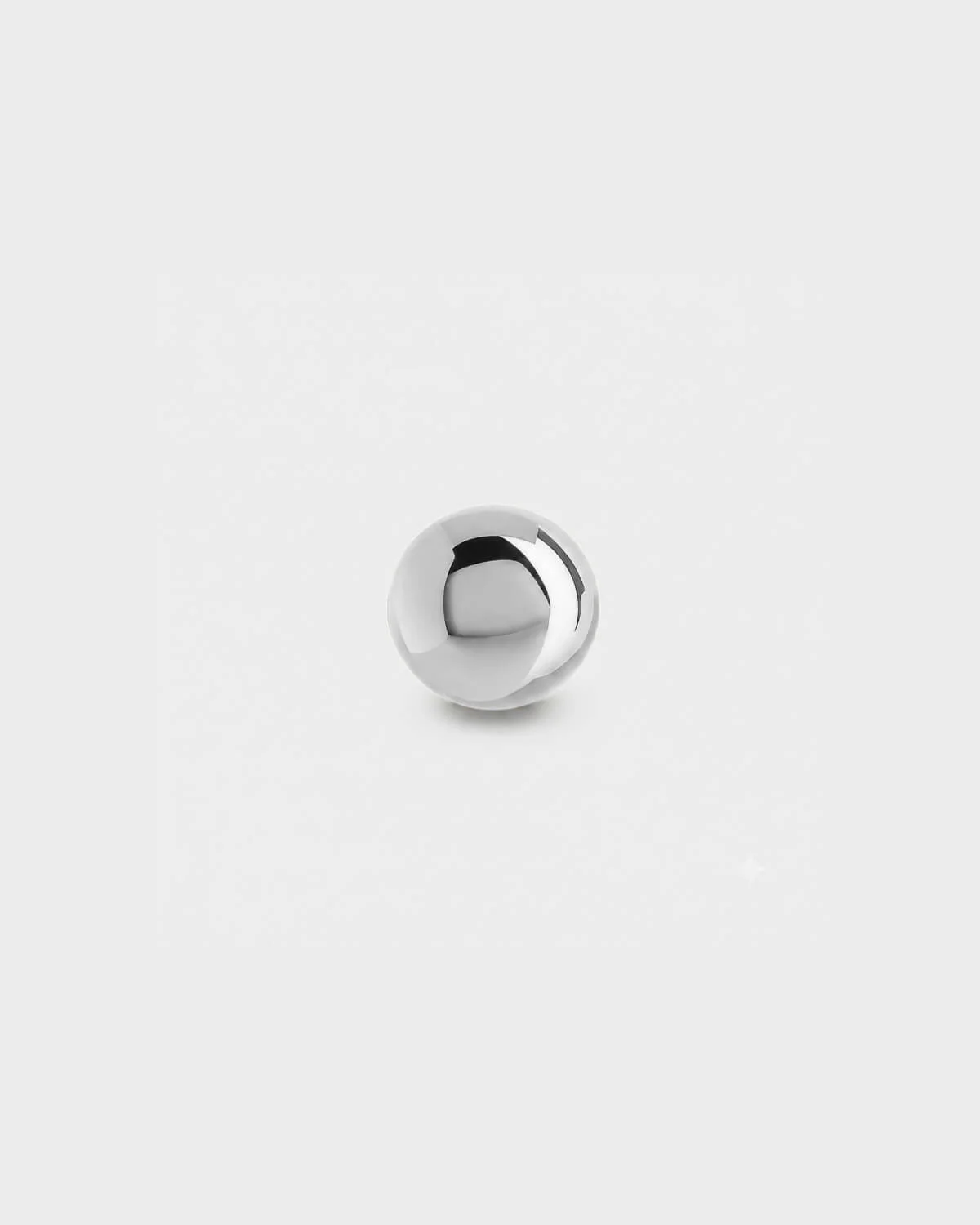 Plain polished silver titanium ball for piercing jewellery on a light grey background