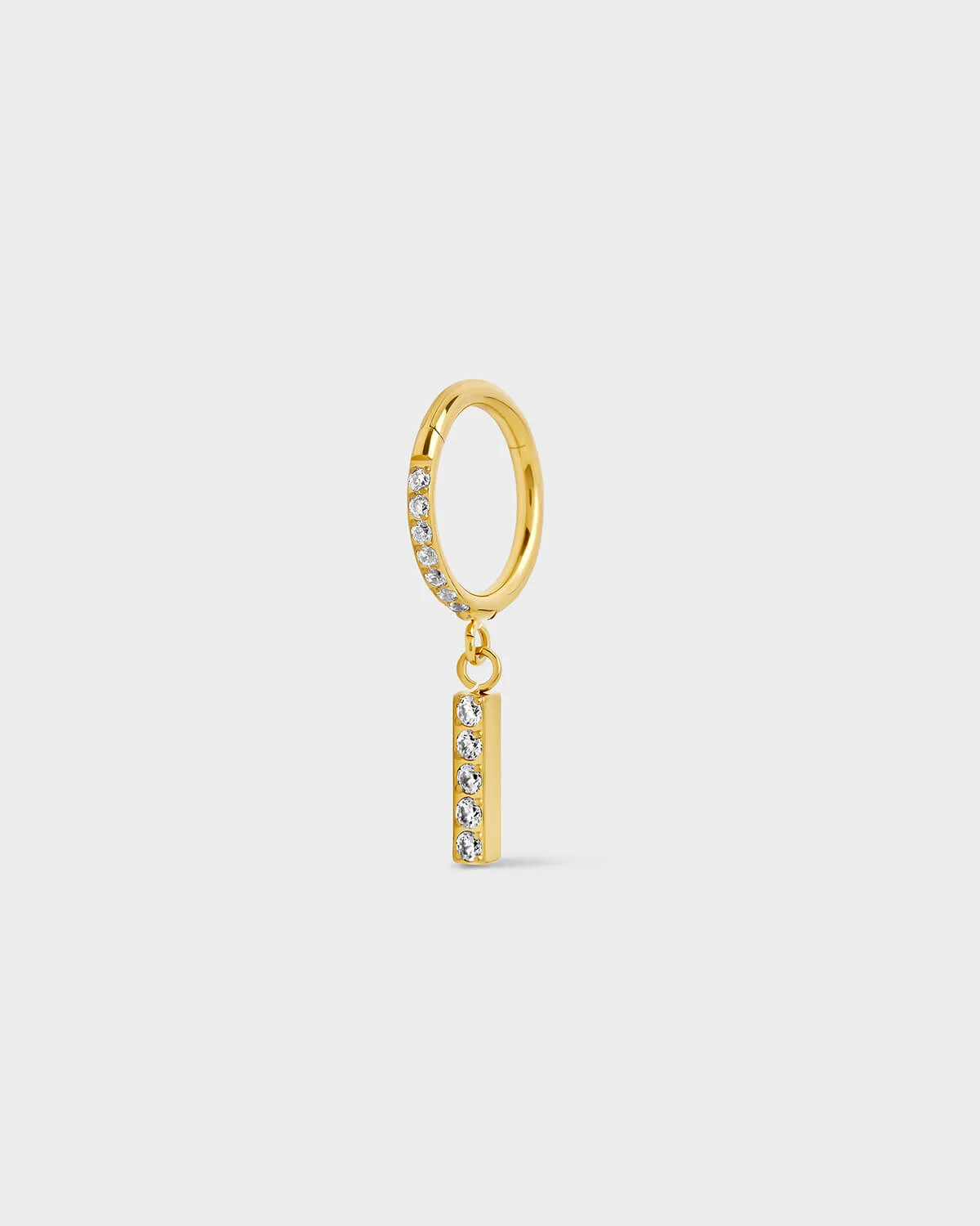 Gold titanium ring with pavé set gems along the front edge, finished with a vertical bar drop accented by a row of matching pavé stones. On a light gray background.
