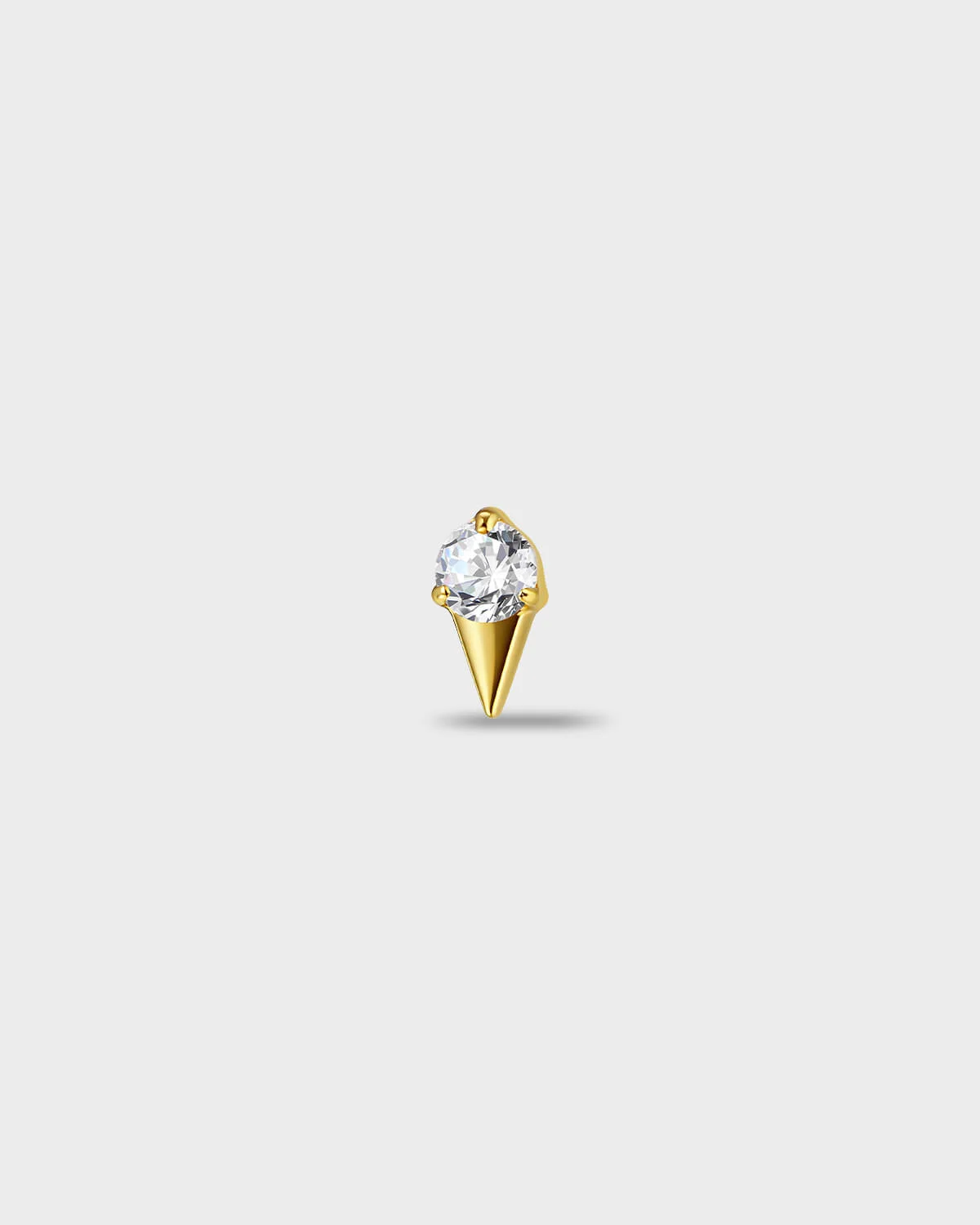 Gold titanium earring with a round-cut clear stone set above a tapered, sculpted base, on a light gray background.