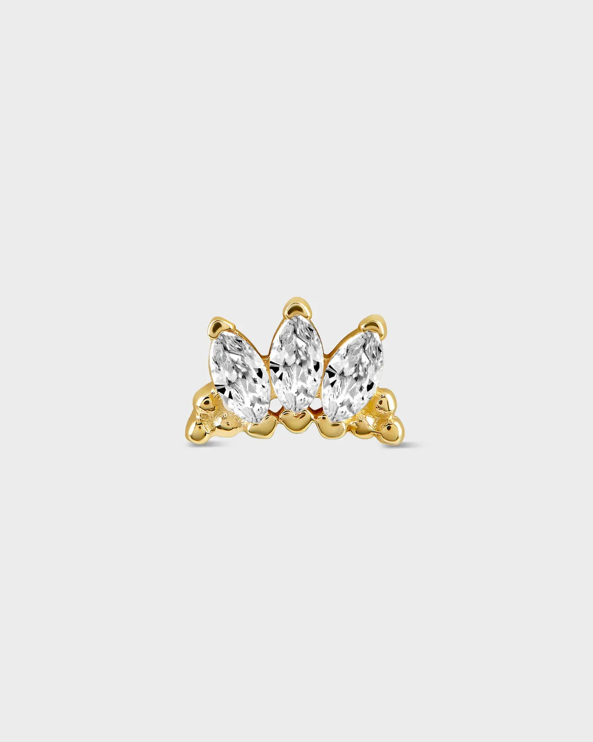 Gold earring with three clear gemstones on a light gray background