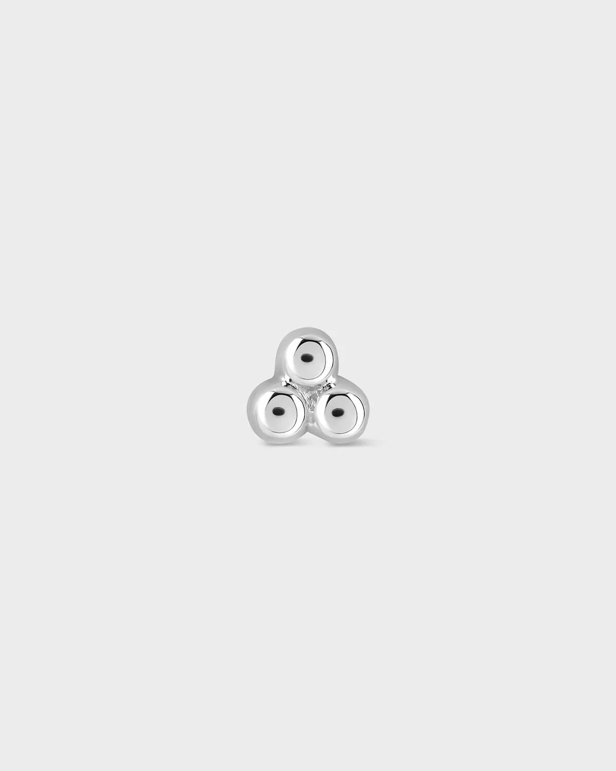 Silver triskele earring on a light gray background