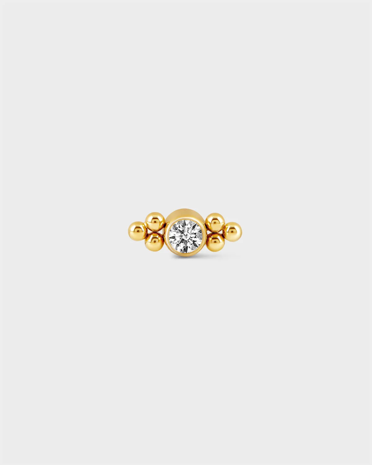 24k Gold titanium bezel set solitaire earring with 3 bead detailing either side on a light grey background.