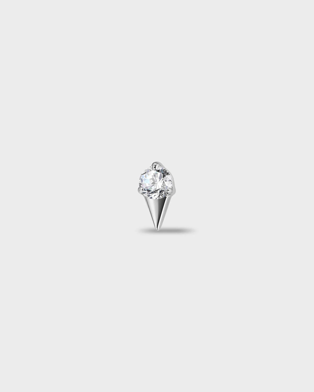 Polished titanium earring with a round-cut clear stone set above a tapered, sculpted base, on a light gray background.