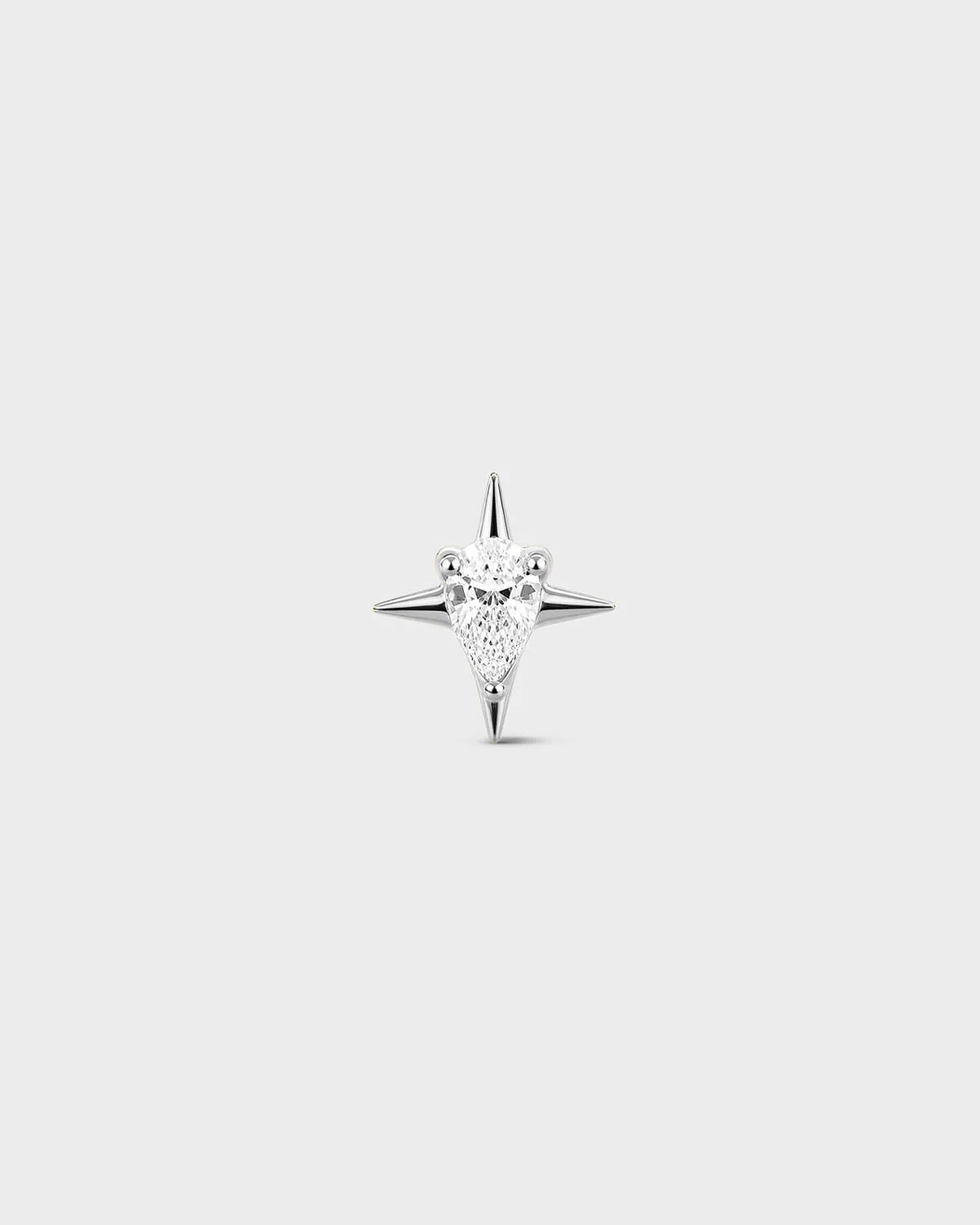 Polished silver titanium threadless end earring with a pear-cut clear stone set within a sculpted four-point star design. On a light grey background.
