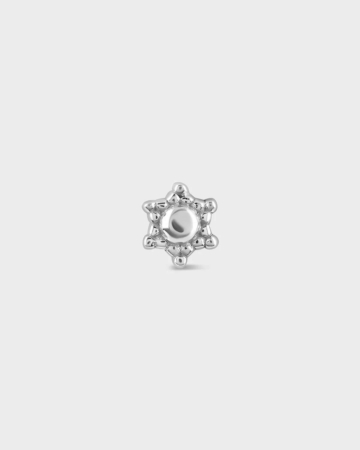 Silver star-shaped charm on a light gray background