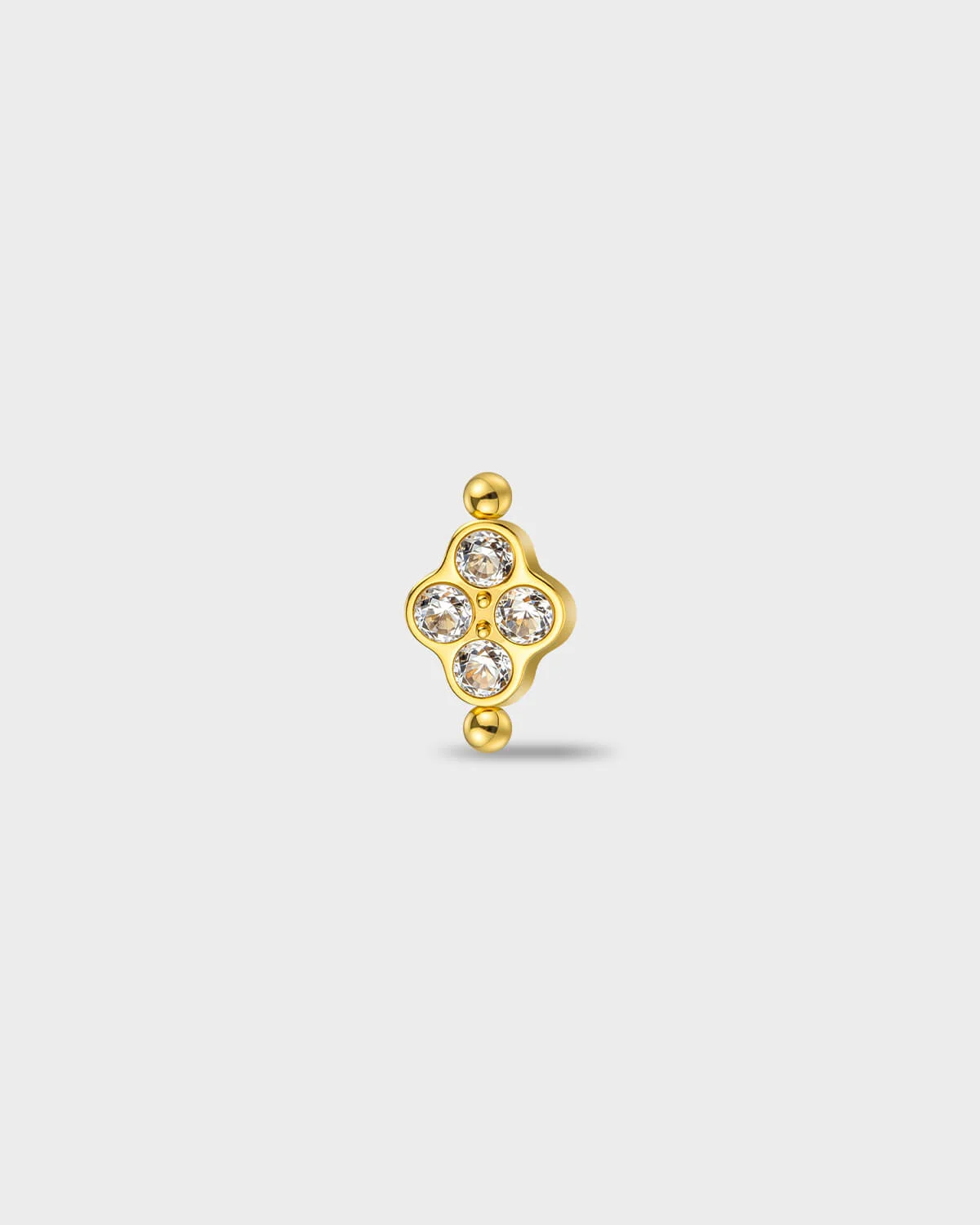 Gold titanium earring with four round-cut clear stones set in a compact cluster, finished with polished bead details at the top and bottom, on a light gray background.