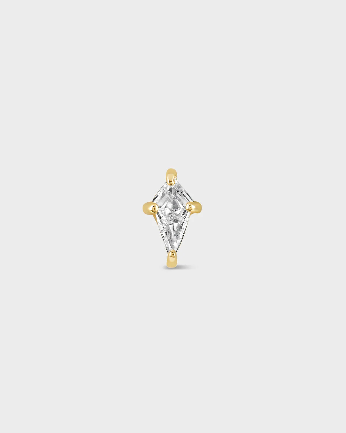 Gold and clear kite shape gemstone earring on a light gray background