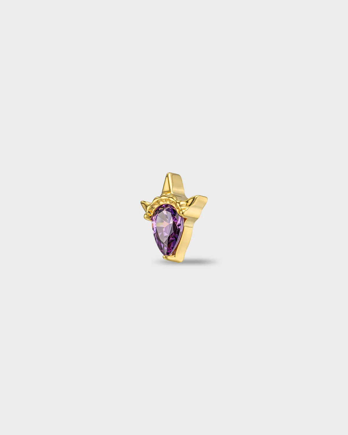 Gold titanium earring with a pear-cut amathyst purple stone set in a sculpted, pointed setting, on a light gray backgroud.
