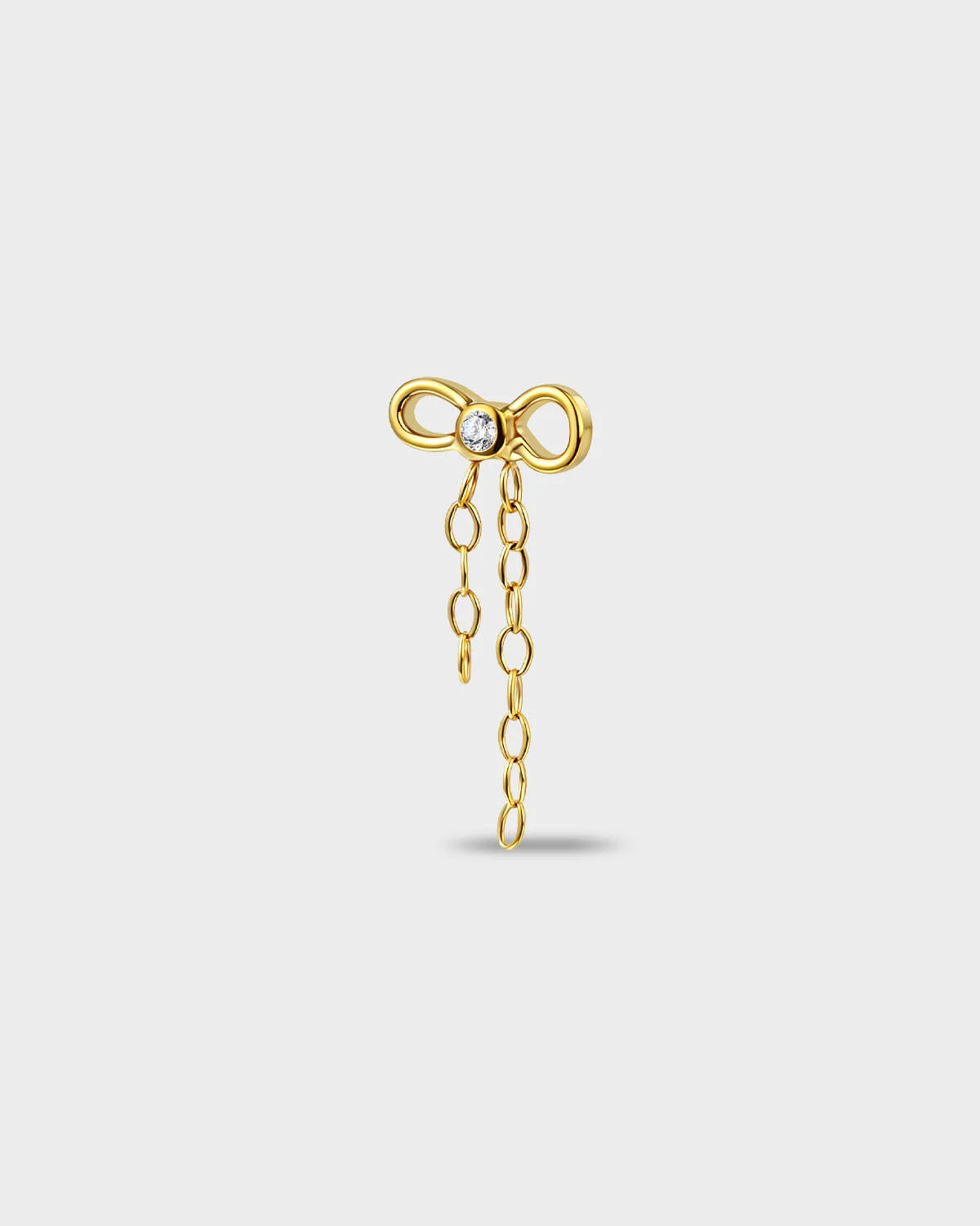 Polished titanium earring with a bow-shaped top set with a clear round stone and a double chain dangle on a light gray background.