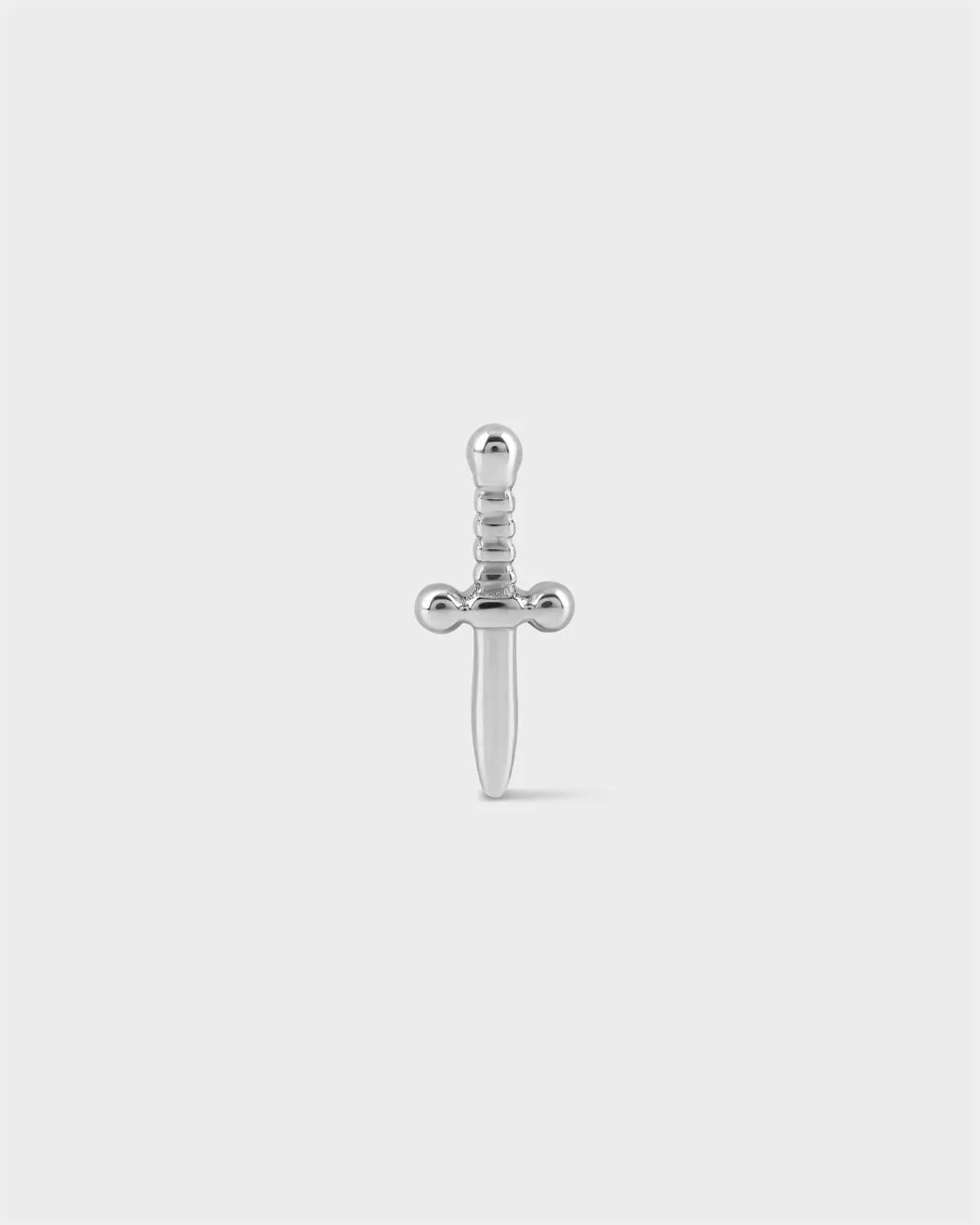 Polished titanium dagger style earring on a light grey background