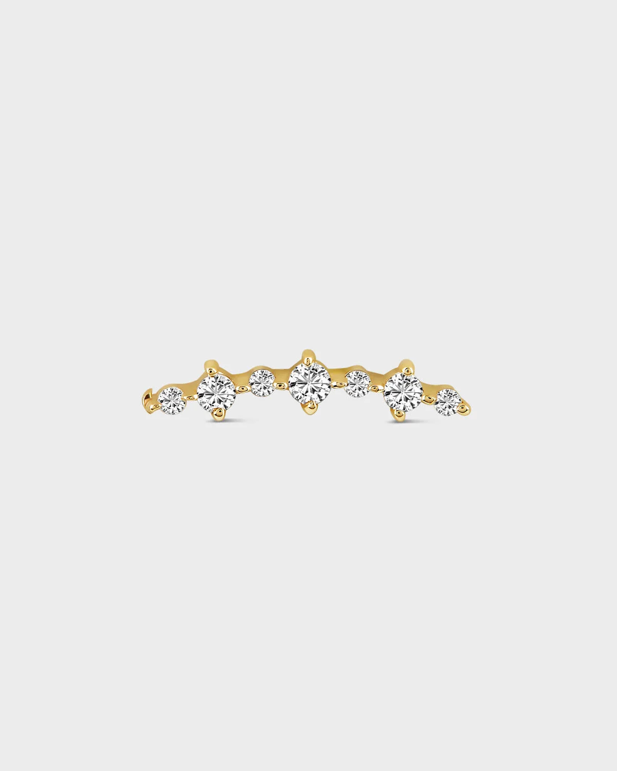 Gold earring with diamonds on a light gray background