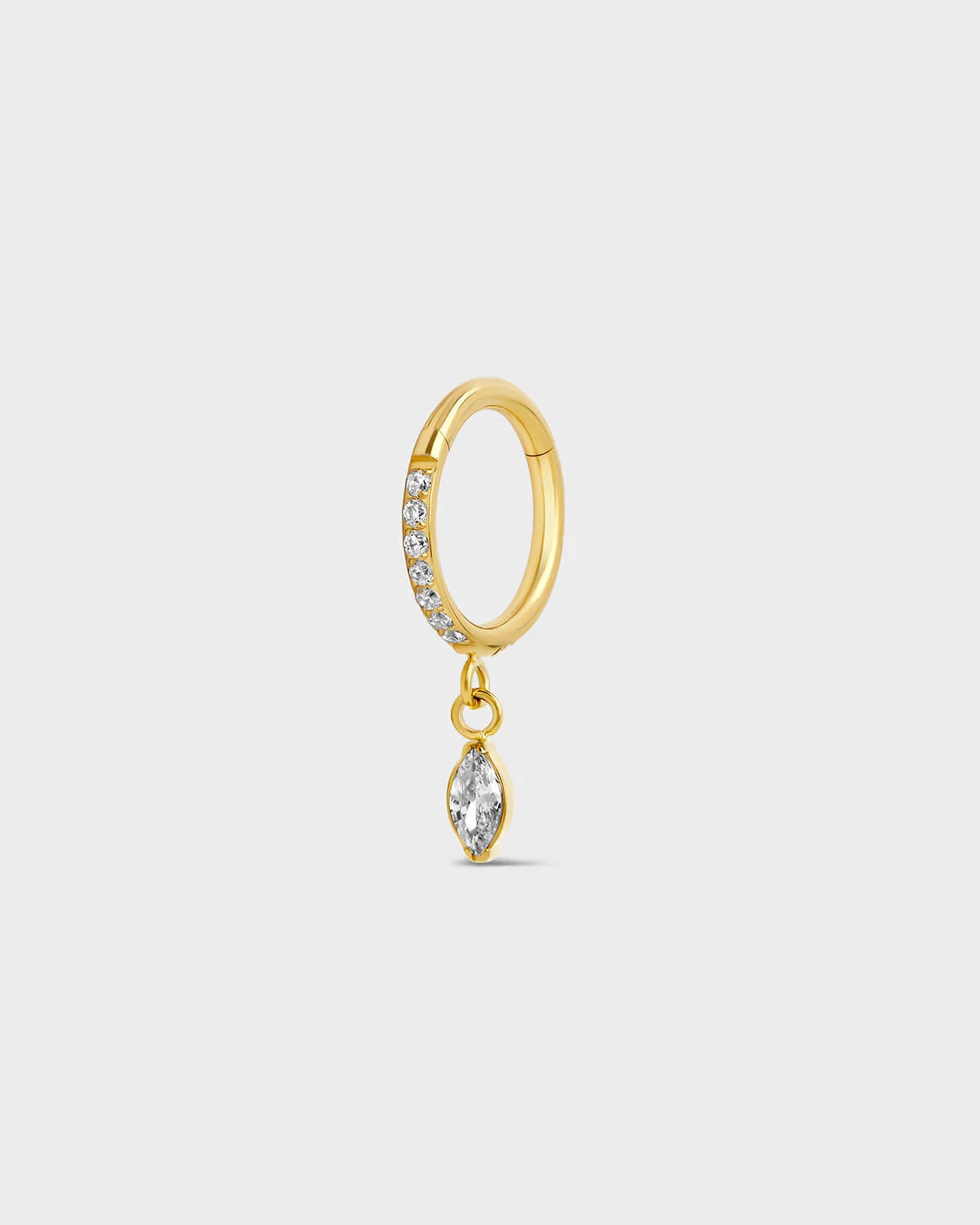 Gold titanium hinged ring with clear pave gemstones around the outer edge and a single dangle marquise charm sat on a light gray background.