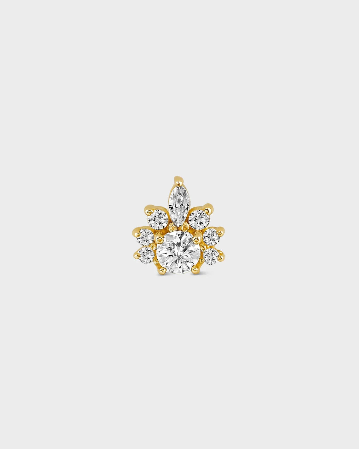 Gold earring with clear gemstones on a light gray background