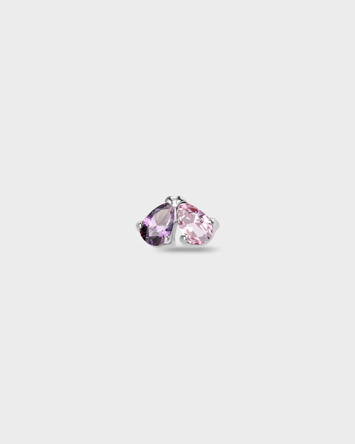 Polished silver titanium earring with two pear-cut stones set side by side, one purple and one pale pink on a light gray background.