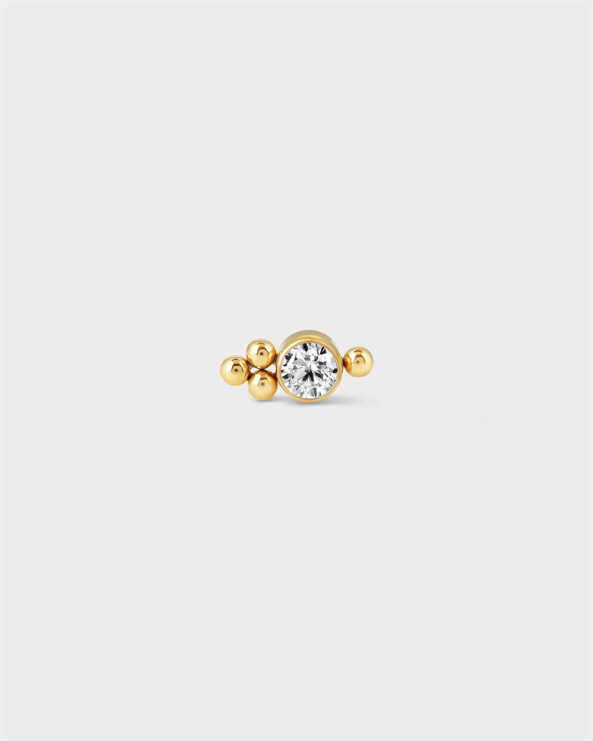 24k Gold titanium bezel set gem earring with 1 decorative bead to one side and 3 beads to the opposite side on a light greay background.